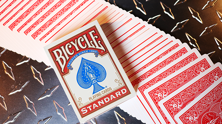 Bicycle Standard red-back playing cards with the box, spread out on a metal surface