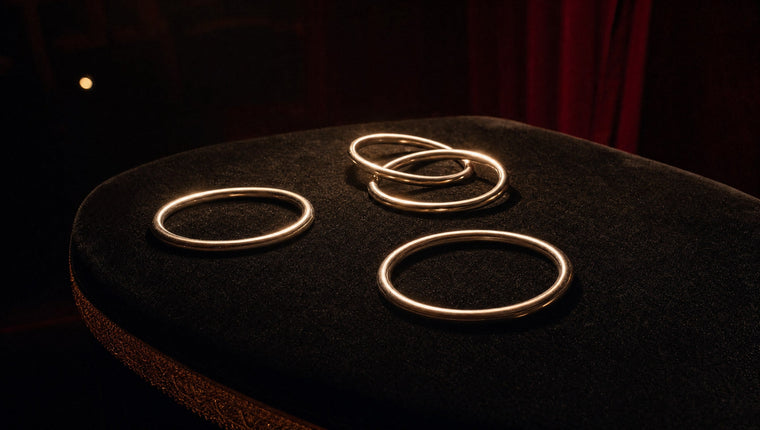 Four polished steel linking rings on black velvet, two of them linked together